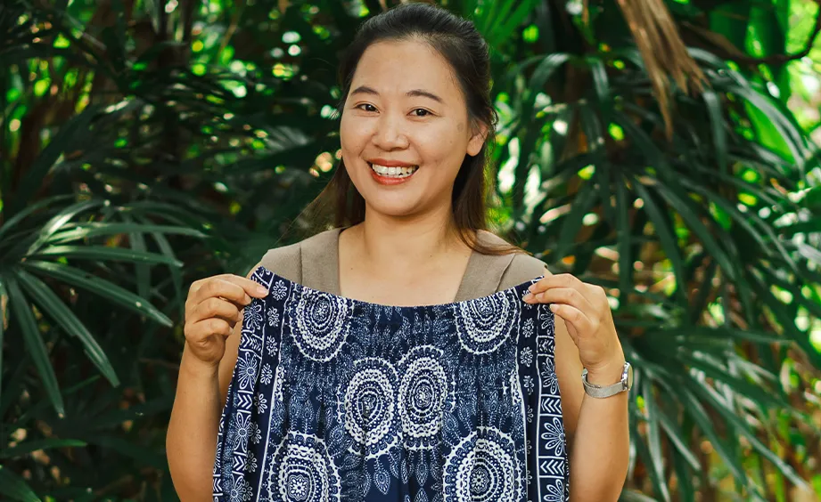 Artisan holding up a length of indigo block-printed fabric