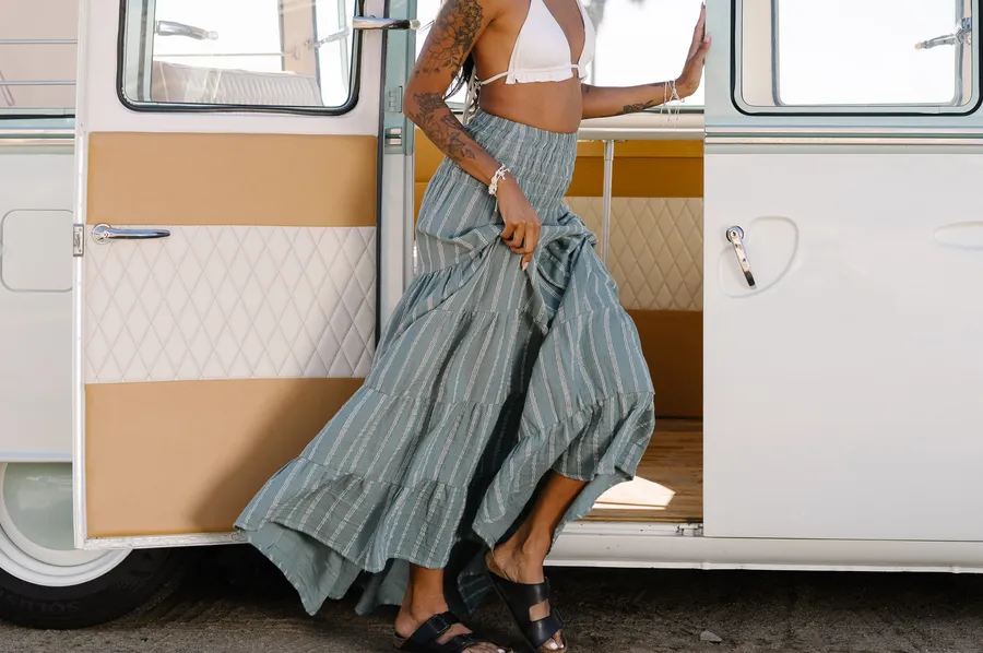 Model in a striped maxi skirt stepping out of a vintage van
